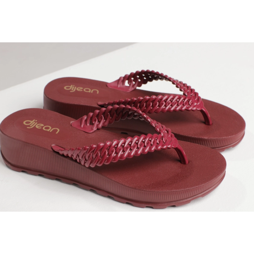 Na imagem temos o chinelo de dedo feminino dijean com correia de correntes trançada com acabamento interno acetinado e acabamento externo em verniz na cor telha bordo