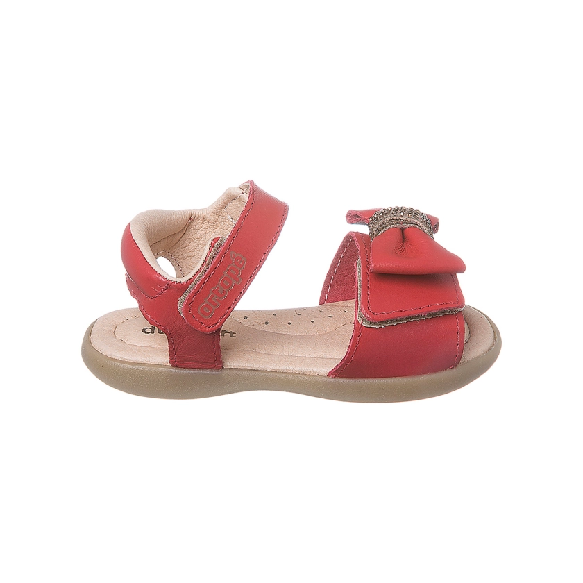 Na imagem temos uma linda sandália infantil feminina Ortopé feita em couro com detalhe de laço e strass na cor vermelha.