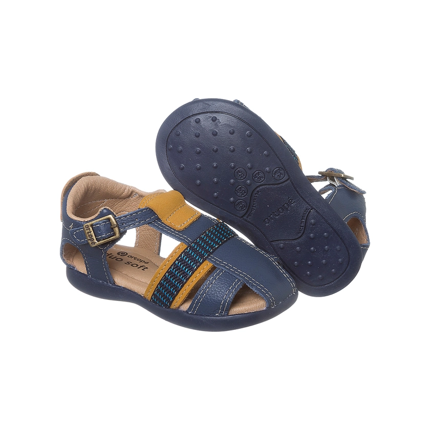 Na imagem temos uma linda sandália infantil masculina Ortopé feita em couro nas cores azul marinho e mostarda.