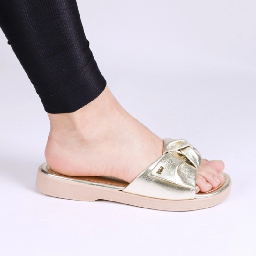 Na imagem temos uma linda Rasteirinha Via Uno na Cor Ouro com um lindo laço que trás todo charme para o calçado