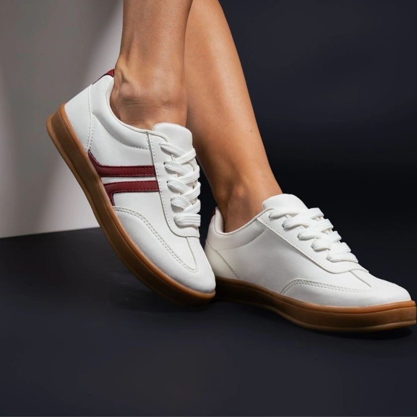 Na imagem temos o tênis feminino dijean casual branco com tiras bordô e fachamento em cadaço
