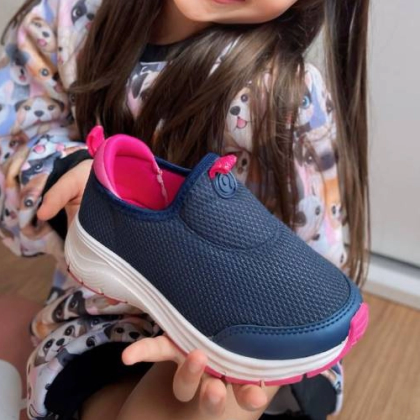 Menina segurando tenis ortope