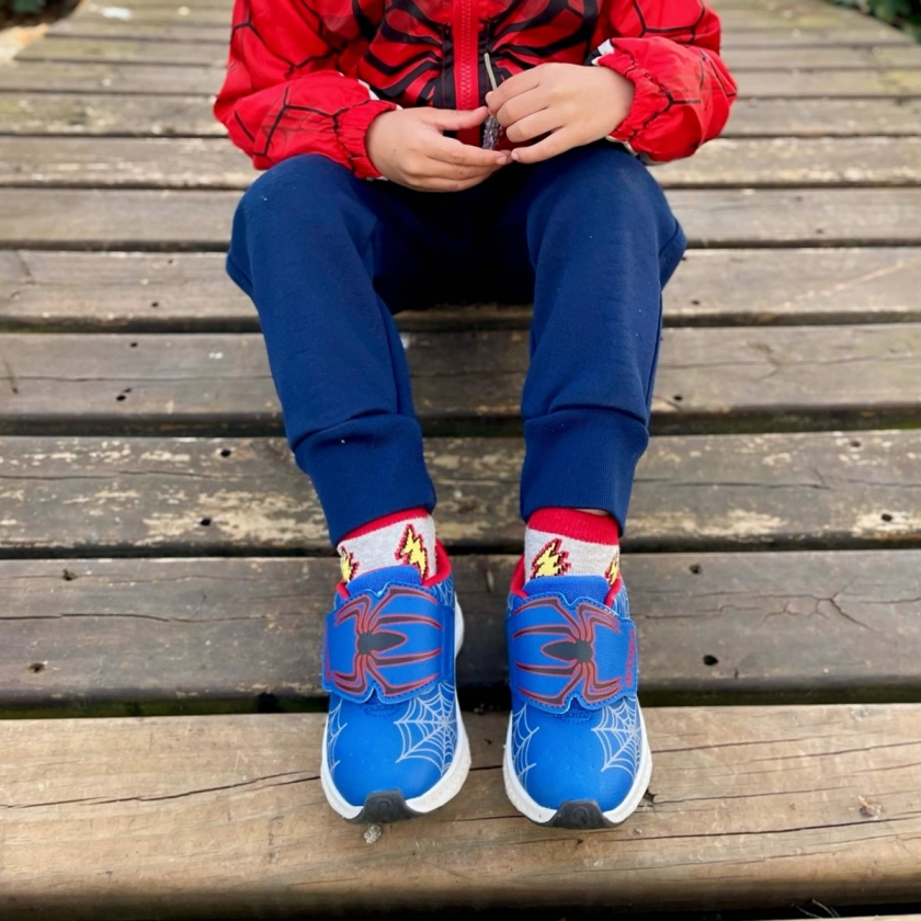 menino calçando o tenis marinho com vermelho aranha