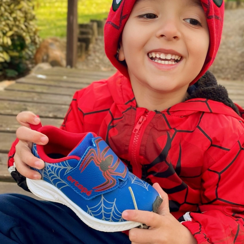 menino segurando o tenis marinho com vermelho aranha